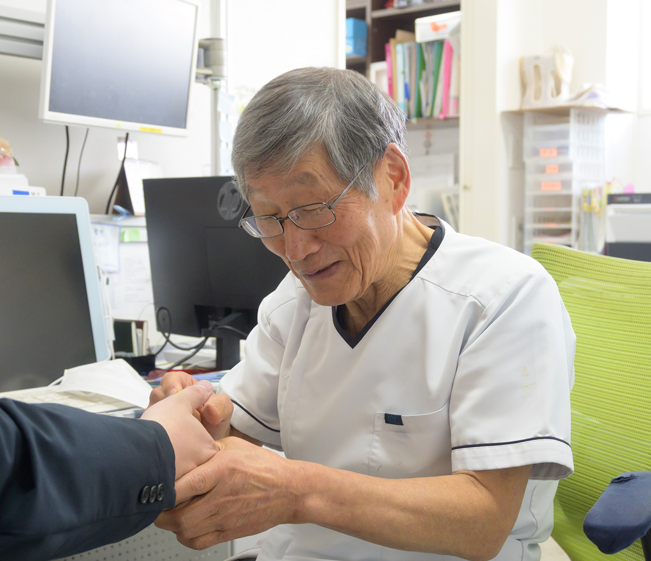 患者様の足を特殊な機器で診察するお医者さん