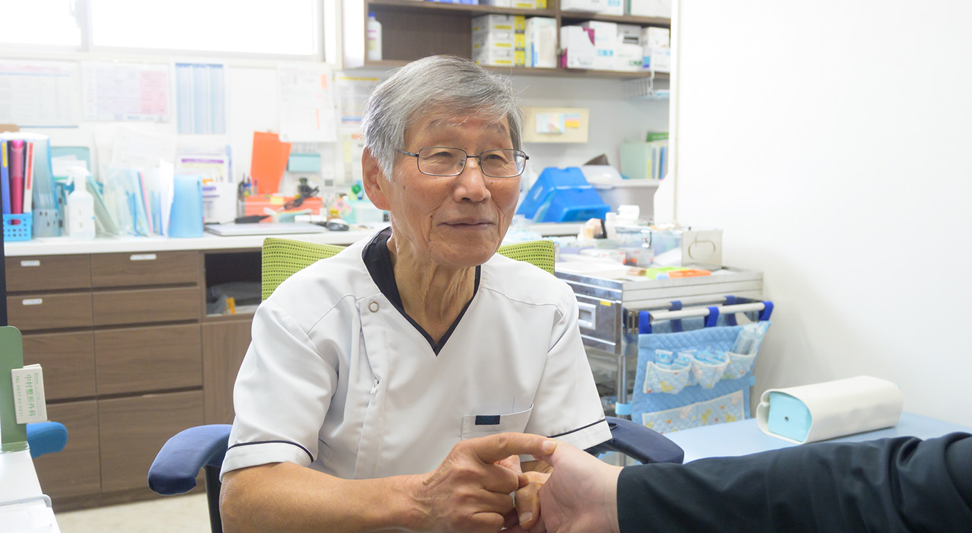 お医者さんが笑顔で患者さんにお話ししている写真