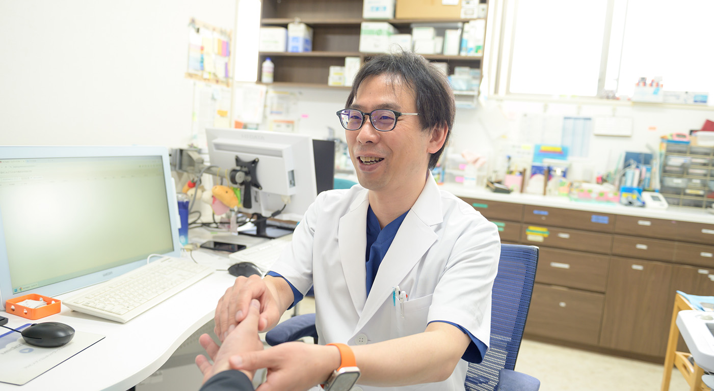 お医者さんが笑顔で患者さんにお話ししている写真